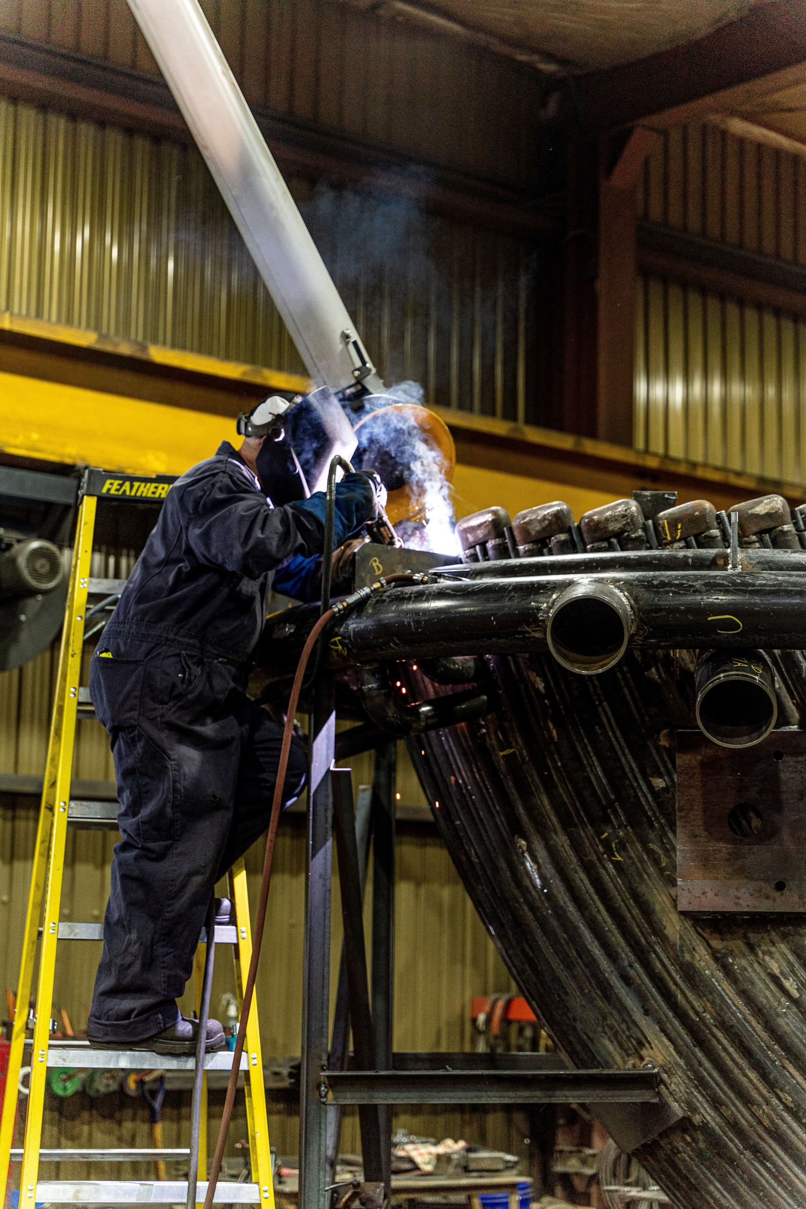 welder performing welding on a water-cooled smoke elbow