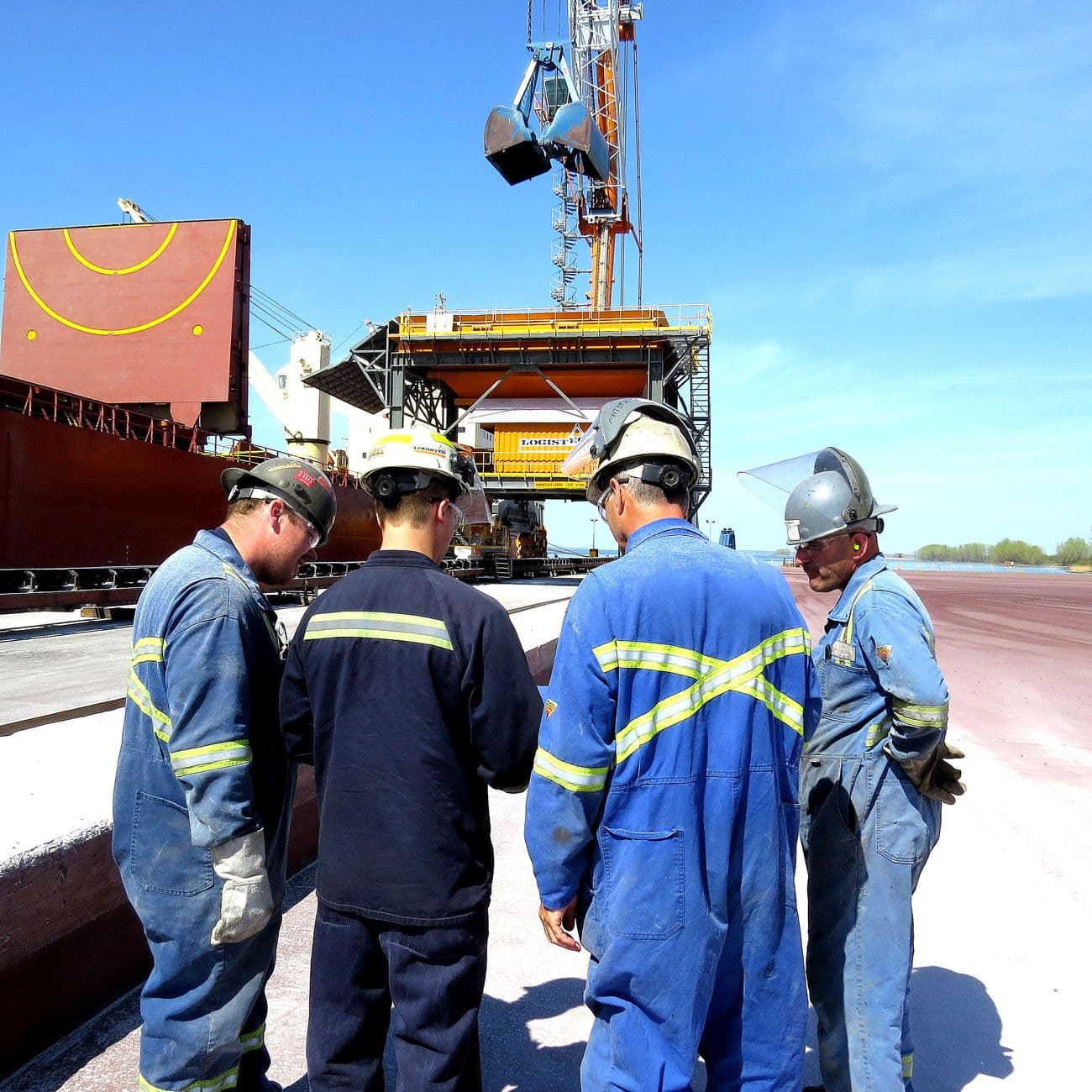 Vue d'ensemble du trémie mobile sur rail à l'extérieur avec quatre employés devant