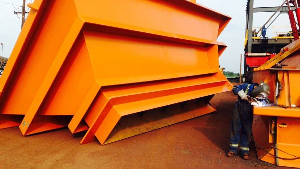 soudeur en chantier entrain de soudé une trémie orange