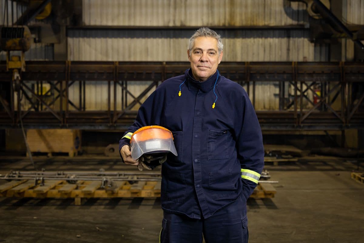 Employé dans l'usine avec un casque dans les mains